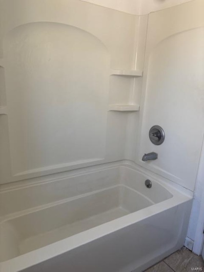 Full bath featuring  shower combination and tile patterned floors