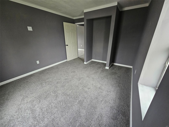 Unfurnished bedroom featuring carpet, a closet, baseboards, and a textured ceiling