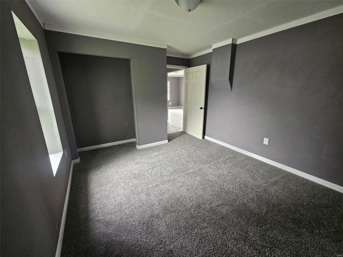 Unfurnished bedroom with ornamental molding, carpet, and baseboards