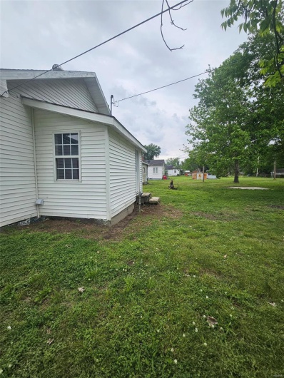 View of side of home with a yard