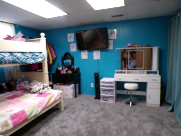 Bedroom with egress, a drop ceiling and carpeted floors.