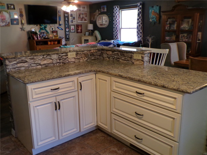 Kitchen Work Counter with open floor plan, stone counters, and breakfast bar.