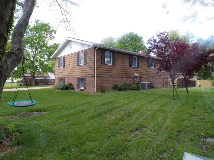 View of side of home featuring a chimney, central AC, and brick/vinyl siding
