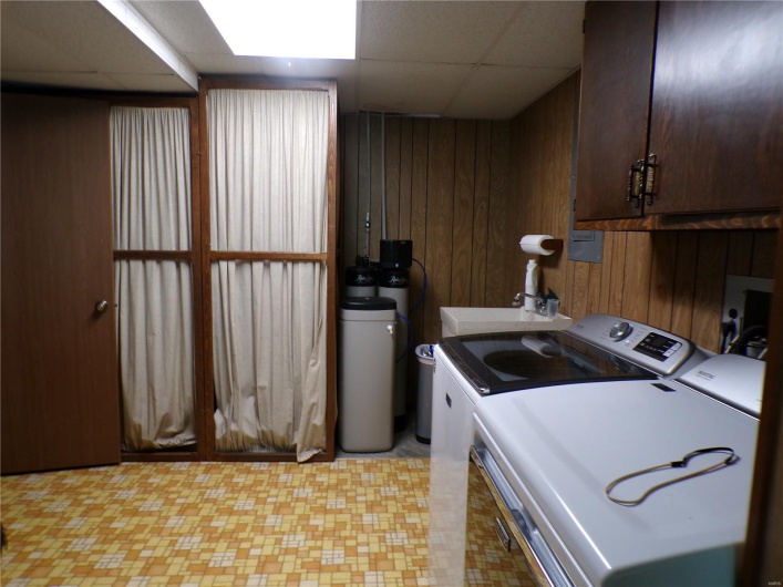 Laundry room featuring utility area and extra cabinet space.