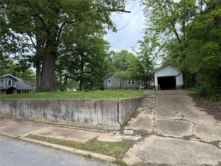 View of front of property featuring an outbuilding, asphalt driveway, and a detached garage