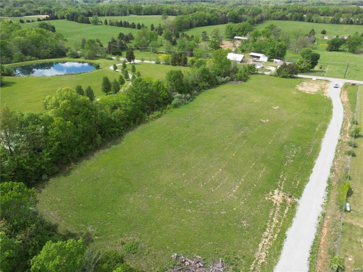 Aerial view of property and surrounding area with a large body of water and rural landscape