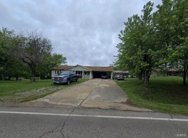 Single story home with concrete driveway, a carport, and a front yard