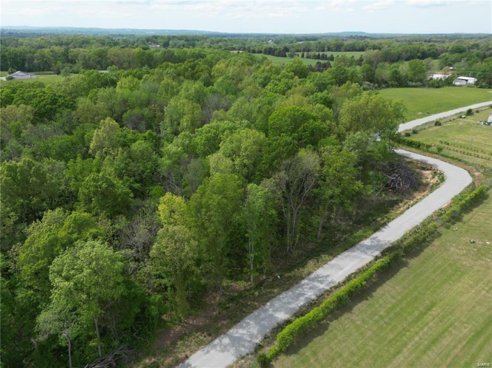 Aerial view of property's location with a forest and rural landscape