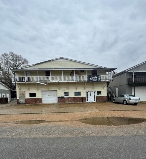 Multi unit property with an attached garage, concrete driveway, and brick siding