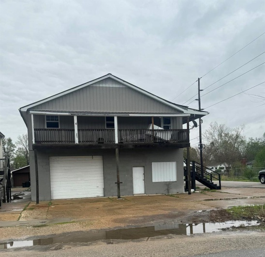 View of front facade with stairway and a garage