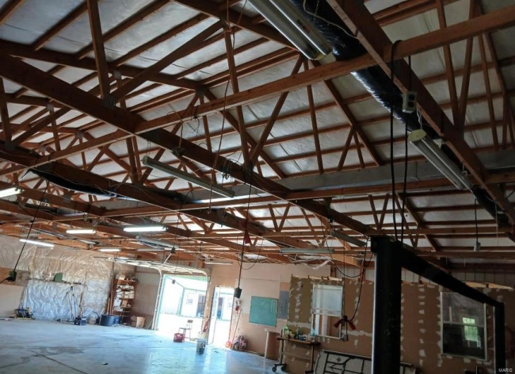 Misc room with a garage, lofted ceiling, and electric panel