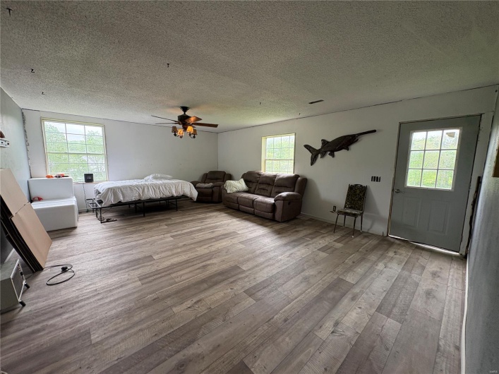 Bedroom featuring wood finished floors, a textured ceiling, and ceiling fan