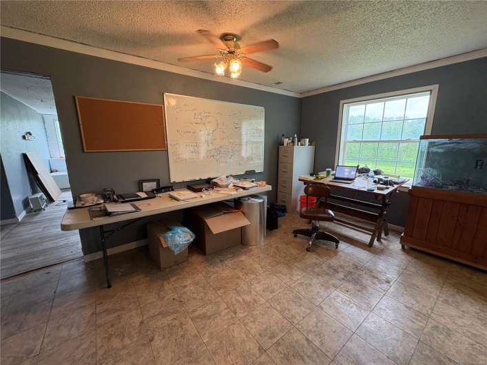 Office featuring a textured ceiling and ceiling fan