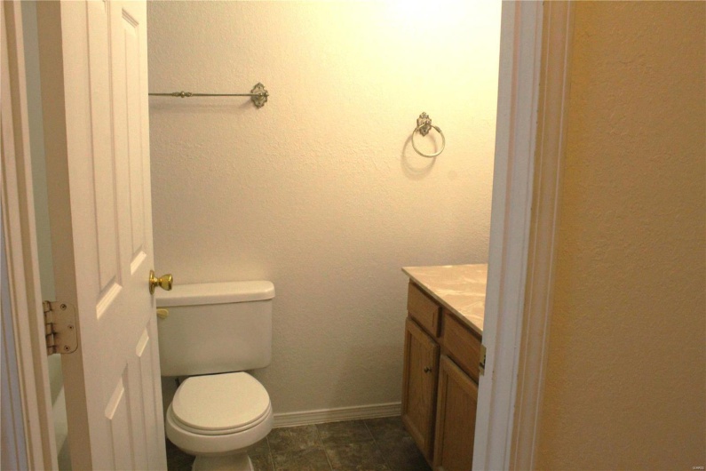 Half bathroom featuring vanity and toilet