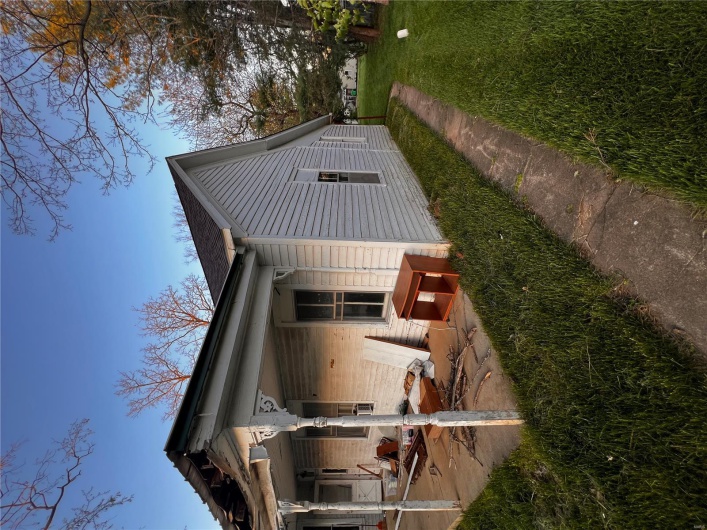 View of side of home with a lawn and a patio