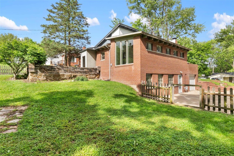 Back of property with a chimney and brick siding