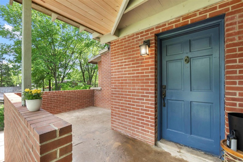 Entrance to property with brick siding and covered porch