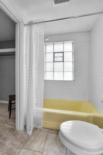 Bathroom with shower / tub combo and toilet