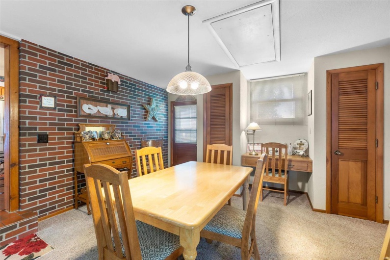 Dining or game area with a healthy amount of sunlight and brick wall
