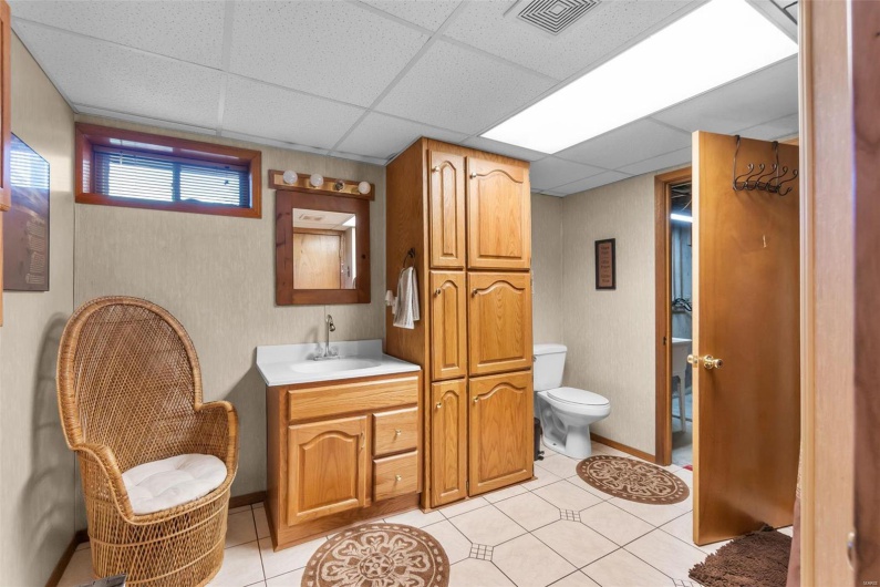 Bathroom with toilet, a paneled ceiling, vanity, and tile patterned floors