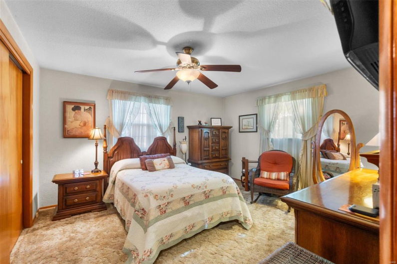 Bedroom featuring light carpet, a closet, a textured ceiling, and ceiling fan