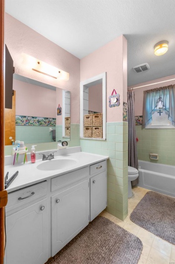 Full bathroom featuring toilet, tile patterned flooring, vanity, tile walls, and a textured ceiling