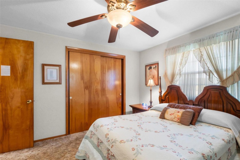 Bedroom with a closet, carpet, and ceiling fan