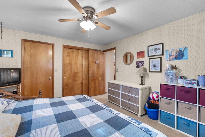 Carpeted bedroom with ceiling fan