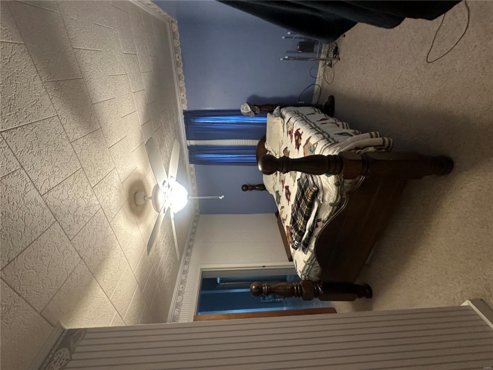 Bedroom featuring ceiling fan and carpet flooring