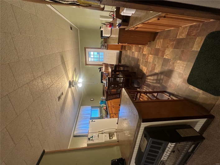 Kitchen featuring fridge, ceiling fan, a kitchen bar, dark countertops, and a peninsula