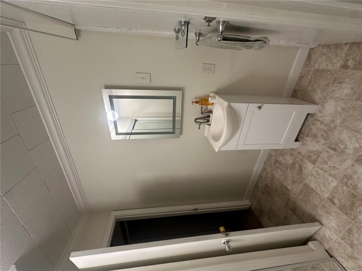 Bathroom with ornamental molding, vanity, and baseboards