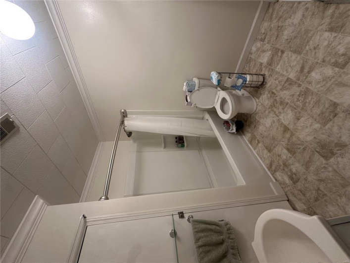 Full bathroom with ornamental molding, shower / tub combo, and toilet
