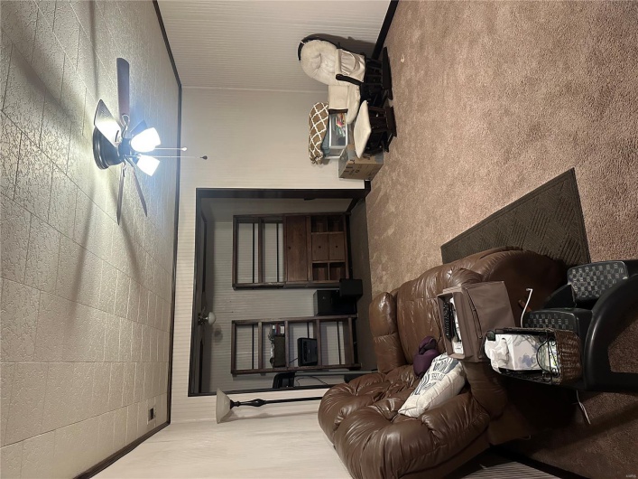 Carpeted living room featuring a ceiling fan