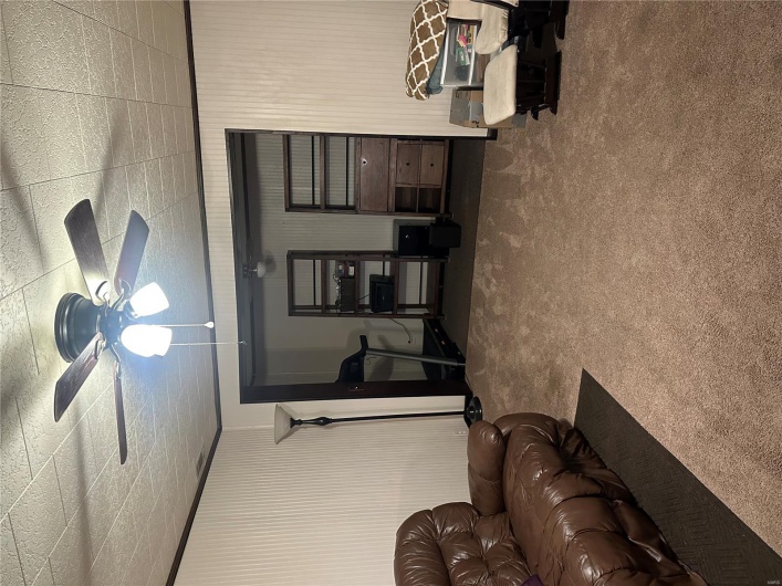 Carpeted living room with a ceiling fan