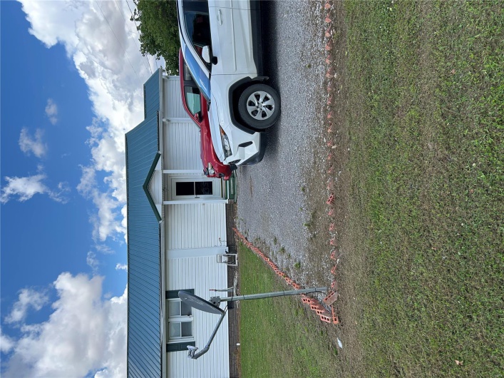 Single story home featuring a front lawn, metal roof, and entry steps