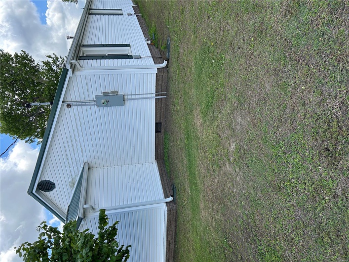 View of property exterior with a lawn and crawl space