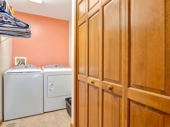 Laundry room with washer and dryer and light tile patterned floors