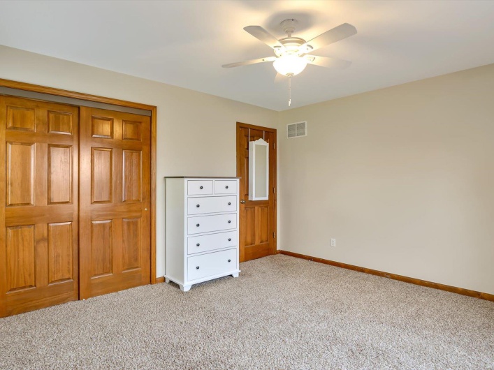Unfurnished bedroom featuring light colored carpet, baseboards, a closet, and a ceiling fan