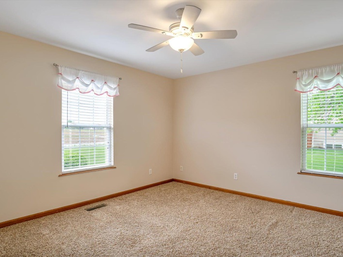 Carpeted empty room with a ceiling fan and baseboards