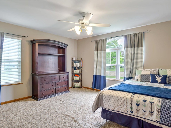 Carpeted bedroom with baseboards and a ceiling fan