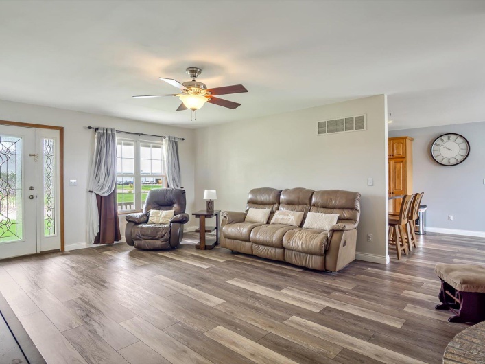 Living area with wood finished floors, a ceiling fan, and baseboards