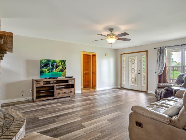 Living area with wood finished floors, baseboards, and a ceiling fan