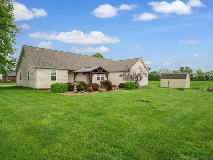 Single story home featuring a front yard, roof with shingles, a storage shed, a gazebo, and an outdoor structure