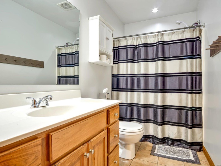 Full bathroom with toilet, tile patterned flooring, vanity, and a shower with shower curtain