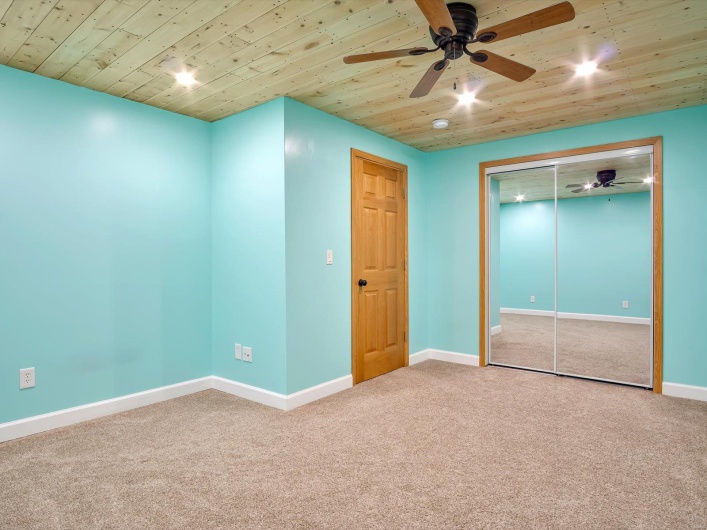 Unfurnished bedroom with carpet floors, baseboards, wood ceiling, a closet, and a ceiling fan