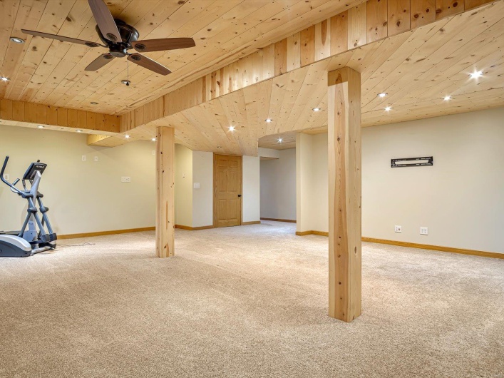 Finished below grade area featuring light colored carpet, wood ceiling, ceiling fan, baseboards, and recessed lighting