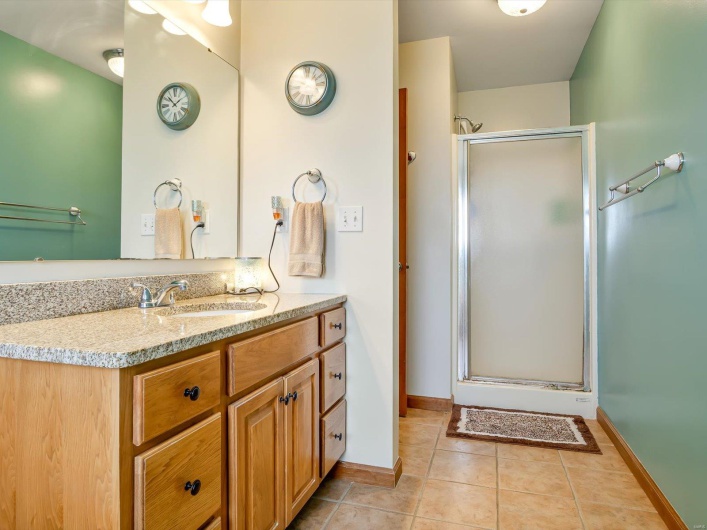 Full bathroom featuring a stall shower, tile patterned floors, vanity, and baseboards