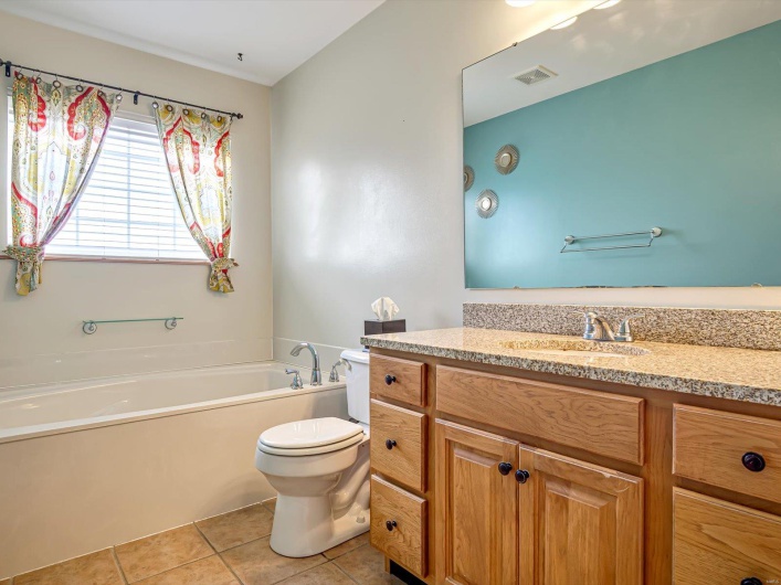 Full bathroom featuring a bath, vanity, tile patterned floors, and toilet