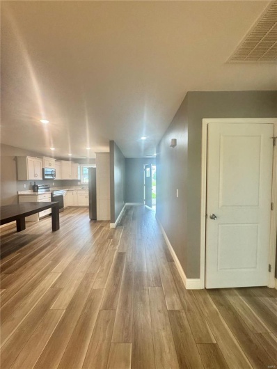 Additional living space with baseboards and light wood-style floors