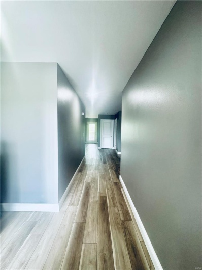 Hallway featuring wood finished floors and baseboards